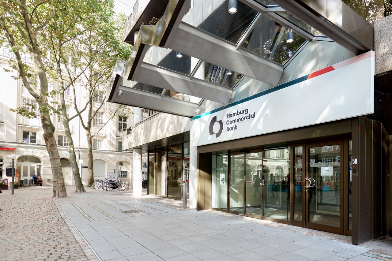 Die Hamburg Commercial Bank AG ist eine private Geschäftsbank, die bei ihren KundInnen mit einer hohen Kompetenz bei der Finanzierung gewerblicher Immobilien punktet und zudem über eine starke Marktposition im internationalen Schiffsgeschäft verfügt.