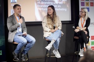 Benita Weiland (Mitte), Marketingleiterin von Swing Kitchen, und Eva Perthen (rechts), Marketingleiterin von druck.at, und wurden im Rahmen eines Fireside Chat bei der JETZT Branding von Lukas Hetzendorfer (links) von Otago über den „Performance-Effekt im Branding und der Branding-Effekt im Performance Marketing“ interviewt.