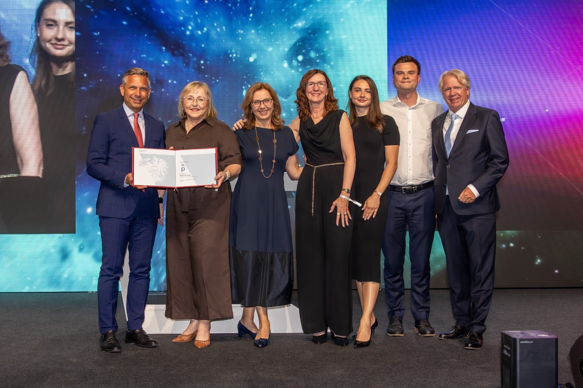 Andritz entschied den Sieg in der Kategorie Investitionsgüter-Marketing beim Staatspreis Marketing 2026 mit dem Marketingkonzept „Creating growth that matters“ für sich: Wirtschaftsminister Wolfgang Hattmannsdorfer und Willy Lehmann, Präsident Austrian Marketing Confederation gratulieren dem Andritz-Marketingteam um Susan Trast (VP Communications & Sustainability) und Doris Reiter (Global Brand Lead) sowie Matthias Reichl (Geschäftsführer) und Sabina Schaffer (Senior Account Director) von der Agentur Reichl und Partner.